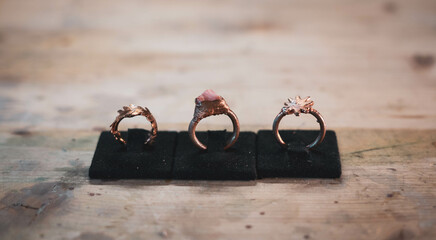 Copper rings arranged in a row. Handmade jewelry with minerals and precious stones set on top....