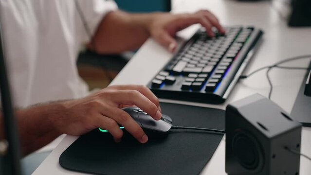 Young hispanic man streamer playing video game using computer at gaming room