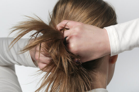 Serie of photos of making a low ponytail with basic elastic hair band. Back view of young woman tied her hair in ponytail.