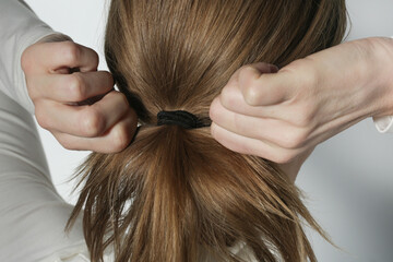 Serie of photos of making a low ponytail with basic elastic hair band. Back view of young woman tied her hair in ponytail. - obrazy, fototapety, plakaty