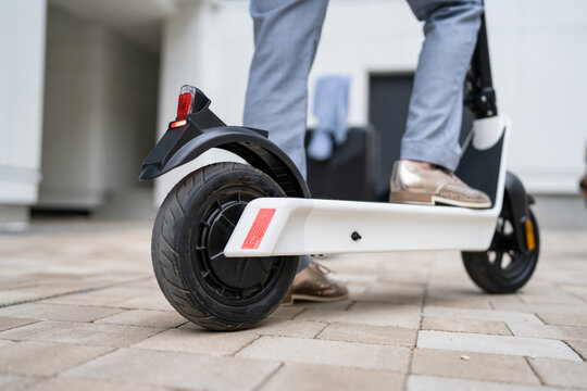 Feet Of Unknown Woman Stand Or Drive Electric Kick Scooter E-scooter