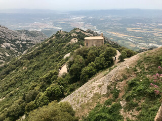 Fototapeta na wymiar Montserrat, Spain, June 2019 - A view of a rocky mountain with Nimrod Fortress in the background