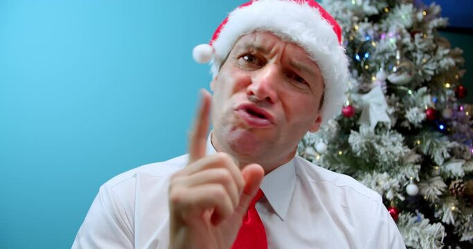 Portrait Serious dad Middle Aged in Christmas hat Santa Claus Man saying No by Finger Sign, looks in camera, disappointed man's face, bad surprise, man emotion something unpleasan.