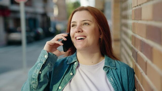 Young beautiful plus size woman smiling confident talking on the smartphone at street