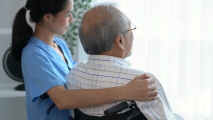 Rear view of a caregiver and her contented senior man gazing out through the window. Elderly health...