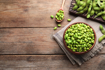 Delicious edamame beans on wooden table, flat lay. Space for text