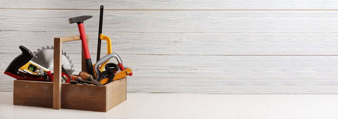 Box with carpenter's tools on white table, space for text. Banner design