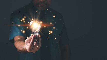 Hand of a man holding illuminated light bulb, concept creativity with bulbs that shine glitter. Inspiration of ideas for sustainable business development, an Idea of innovation and inspiration concept
