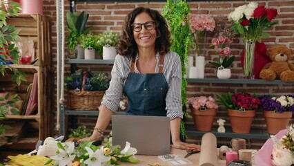 Middle age woman florist smiling confident standing at flower shop