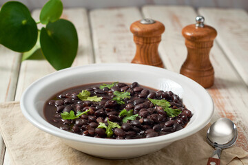 Black bean soup in a bowl on a rustic table.