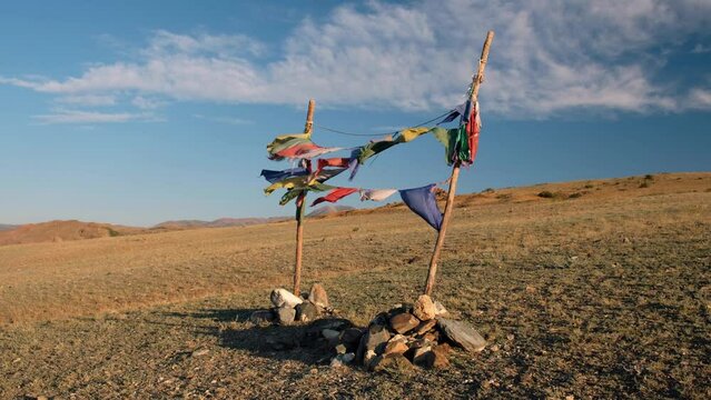 Religious tibetan buddhist prayer flags are flutter in the wind on blue sky background.