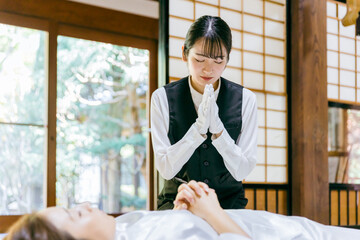仏衣を着せる葬儀スタッフ（納棺師）
