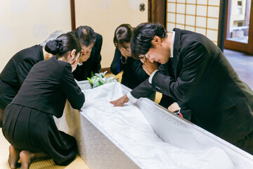 お葬式の納棺式で号泣する親族
