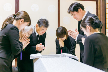お葬式で納棺の儀をする遺族
