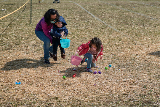 Mom With Two Kids Are Doing A Race And Easter Egg Hunt At The Fair