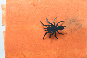 paper spider glyph isolated on orange tissue paper