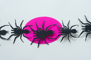 black paper spider glyphs crawling over a pink oval