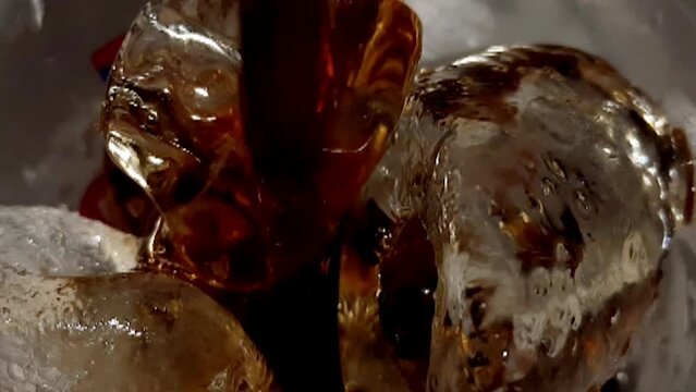 Close up shot of pouring black coffee into  ice cube.