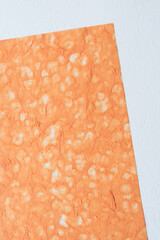 tactile orange tissue paper on scrapbook paper embossed with florals