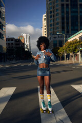 Portrait of young beautiful women with afro hair in the city with rolllerskates