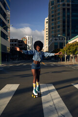Portrait of young beautiful women with afro hair in the city with rolllerskates