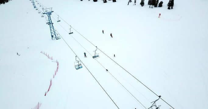Aerial Forward Shot Of People Skiing By Dogs Enjoying In Snow Under Ski Lifts - Canwell Glacier, Alaska