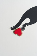 elegant, shapely hand silhouette touching a wooden heart painted red