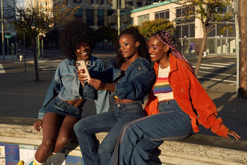 Fototapeta premium Portrait of young friend group together in the city on the phone taking selfies 