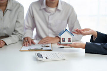 Couple entered into a house sale contract with a real estate agent. Hand over the house keys and calculate the installment and mortgage expenses and make insurance and sign contracts.