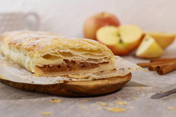 apple pastry strudel roll with cinnamon on grey marble table
