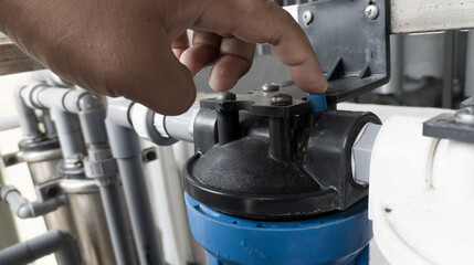 The man pressing the pressure relaease button for replace the  case water filter.