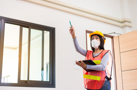 Asian Women Home Inspector Surveyor Wearing Vests And Hard Hat At New Property