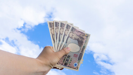 手に持った一万円札