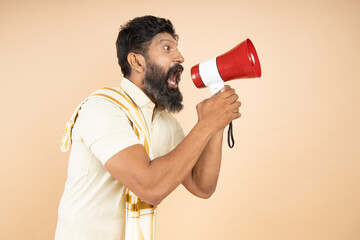 South indian man scream or shouting in megaphone announce discounts sale Hurry up isolated on beige...