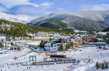 View of base village in Colorado, USA, ski resort on nice winter day; mountains in background