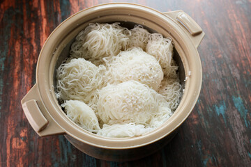 Noolappam Idiyappam rice noodles a popular traditional steam cooked Kerala breakfast dish with hot and spicy egg roast curry on a houseboat Alleppey India. South Indian food. noolputtu Sri lankan