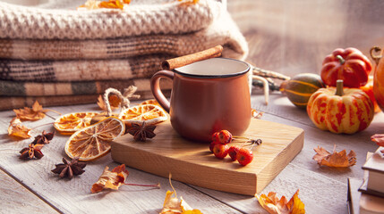 Autumn mood, autumn atmosphere. A cup of coffee, pumpkins, knitted warm blankets, books, autumn leaves on the windowsill.