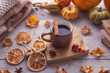 Obraz na płótnie Canvas Autumn mood, autumn atmosphere. A cup of coffee, pumpkins, knitted warm blankets, books, autumn leaves on the windowsill.