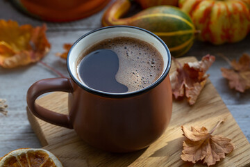 Autumn mood, autumn background. Cup of coffee, pumpkins, autumn leaves. Cozy atmosphere.