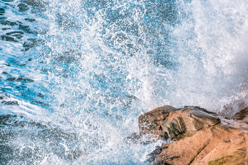 Beautiful waves of the Pacific Ocean beat against the rocky shore, close-up, pastel colors