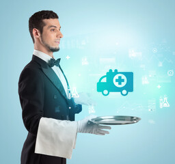 Handsome young waiter in tuxedo holding healthcare icons on tray