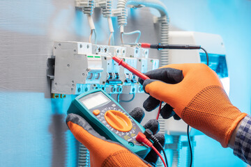 electrician work tester measuring voltage in fuse board. electrical engineering concept. Selective...