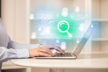 Hands working on laptop with digital icons