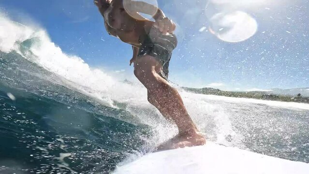 POV Surfer riding blue ocean wave surfing