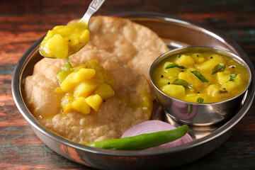 Puri Bhaji North Indian Poori with aalu bhaji , aalu sabji potato spicy recipe breakfast food a deep fried bread of whole wheat flour. poori masala in restaurant Kerala, India, Sri Lanka.