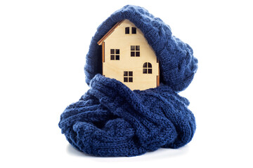 Wooden toy house with warm hat and scarf isolated on white background