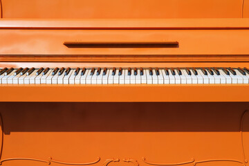 Detail of an orange colored piano