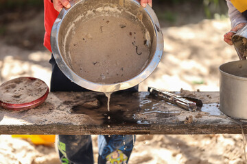 Preschool children playing in sandpit making mud pies at kindergarten © Caseyjadew