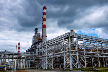 Panorama of the building of an industrial metallurgical enterprise against a blue sky with clouds. Urban landscape with a metal structure. High quality photo.
