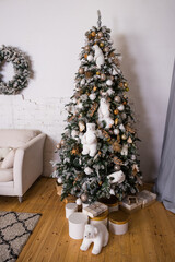 Richly decorated christmas tree with golden ornaments in living room with a golden presents and a polar bear.Christmas home interior. Happy new year